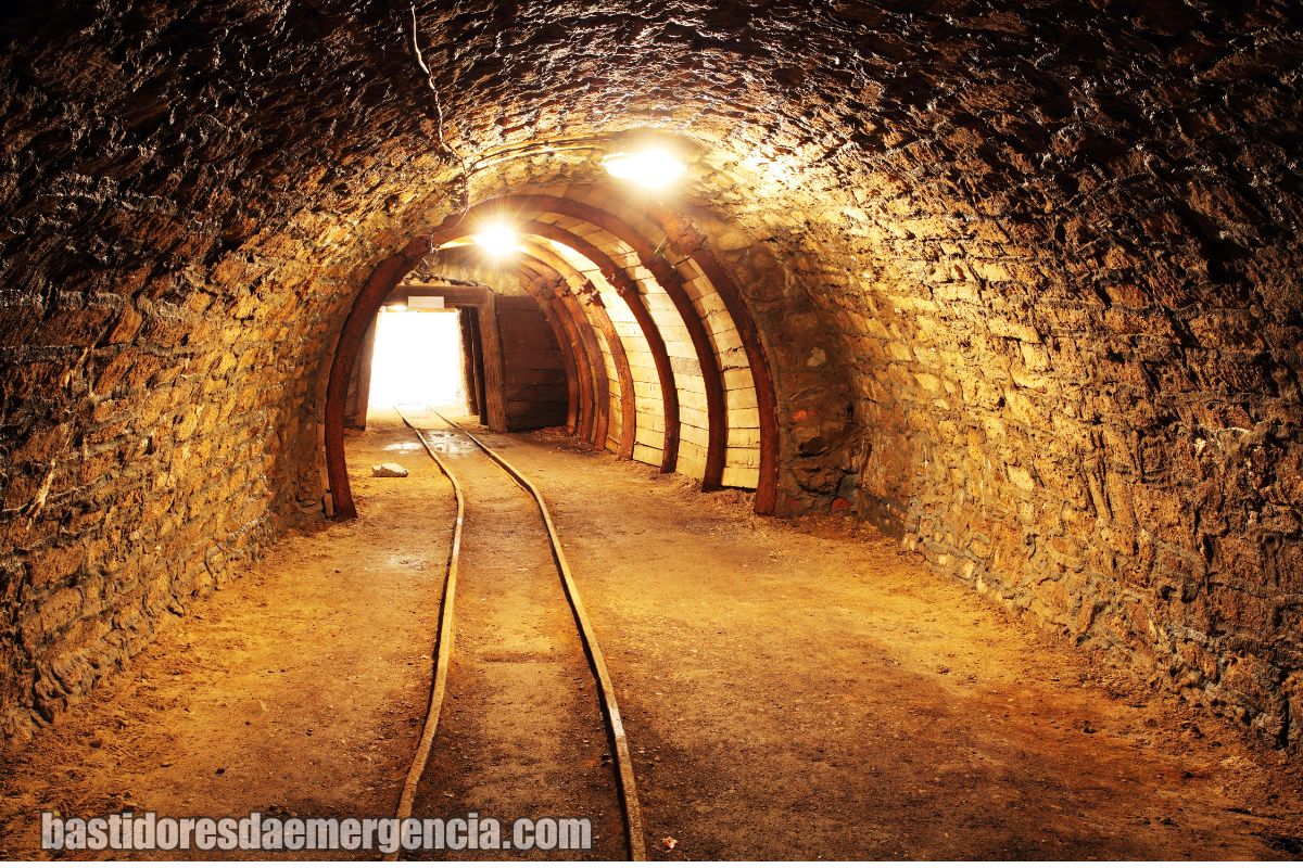Túnel de infraestrutura com cabos; risco elétrico e atmosfera perigosa.